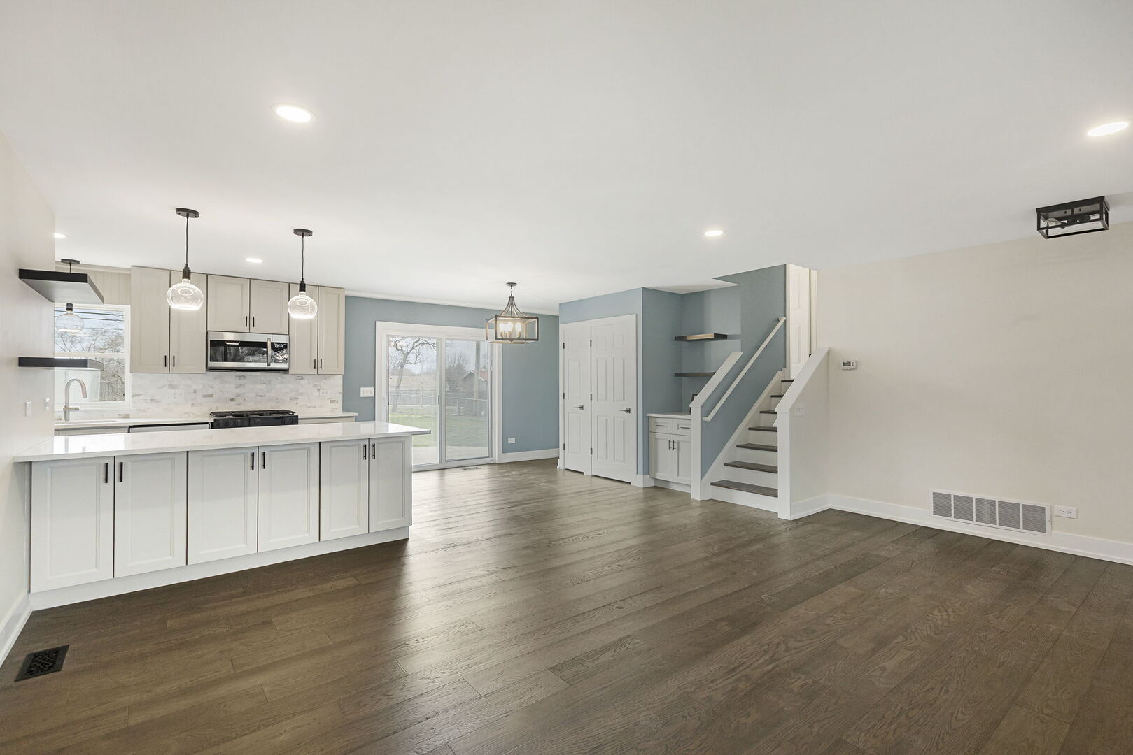 1910 Ashley Road Hoffman Estates, IL 60169 - Photo 3 of 30 a large white kitchen with white cabinets and wooden floor