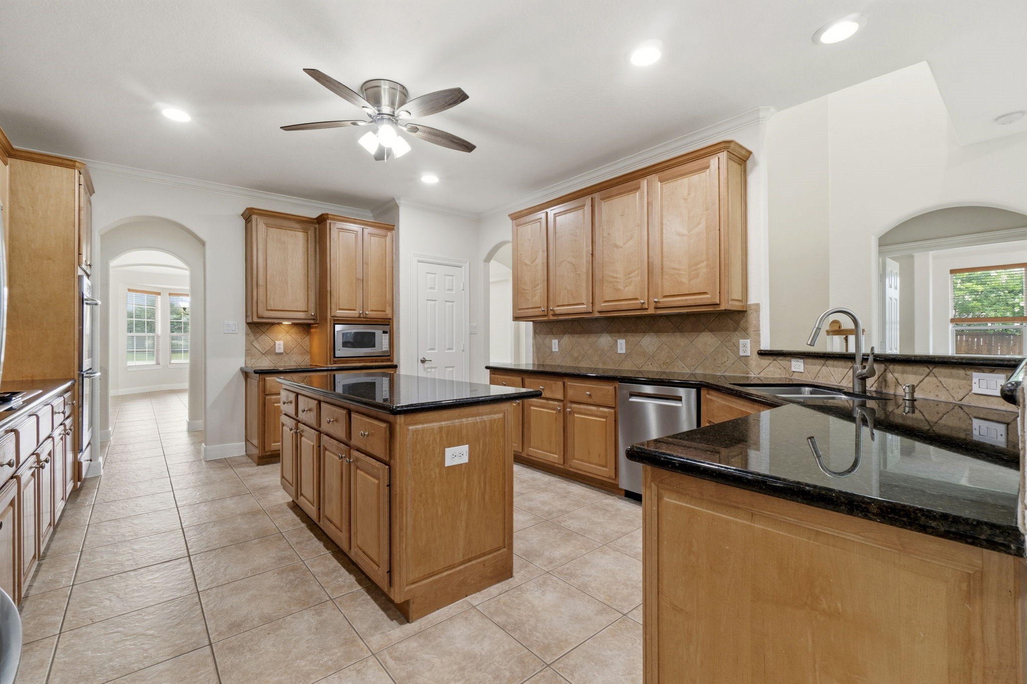 2716 Silverstone Way Conroe, TX 77304 - Photo 9 of 27 Tall cabinets and granite countertops elevate this kitchen.