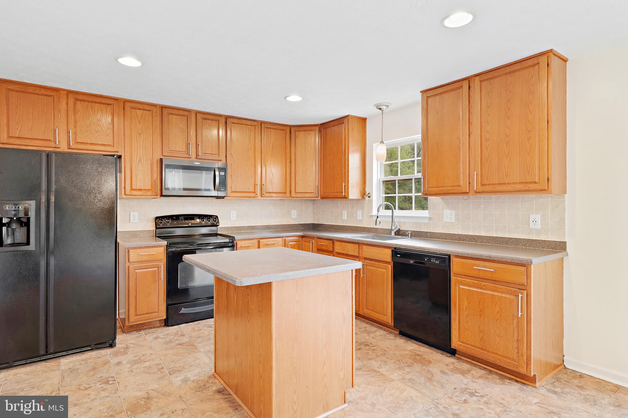 1612 Cattail Commons Way Denton, MD 21629 - Photo 21 of 67 a kitchen with stainless steel appliances granite countertop a stove a sink dishwasher a refrigerator and a microwave