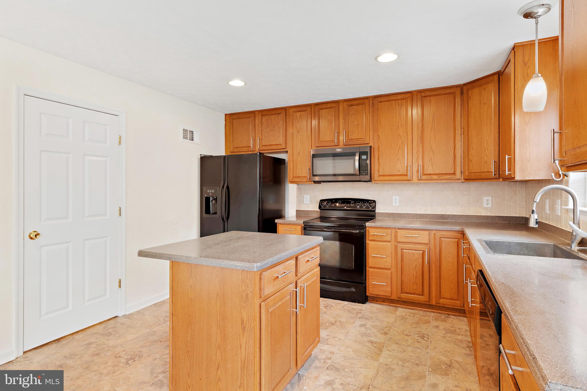 1612 Cattail Commons Way Denton, MD 21629 - Photo 22 of 67 a kitchen with stainless steel appliances granite countertop a refrigerator a sink a stove a microwave and island