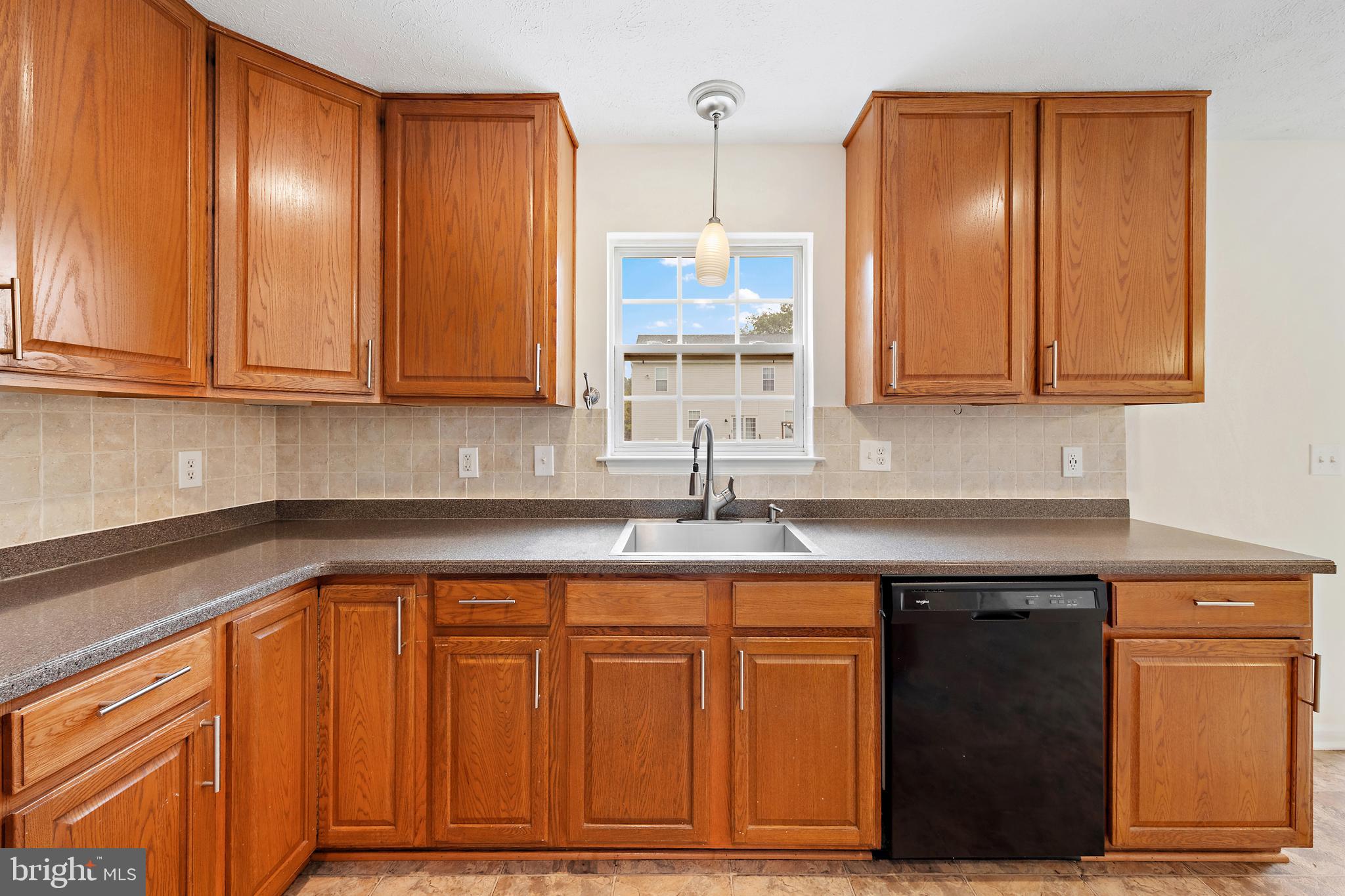 1612 Cattail Commons Way Denton, MD 21629 - Photo 25 of 67 a kitchen with granite countertop wooden cabinets and a sink