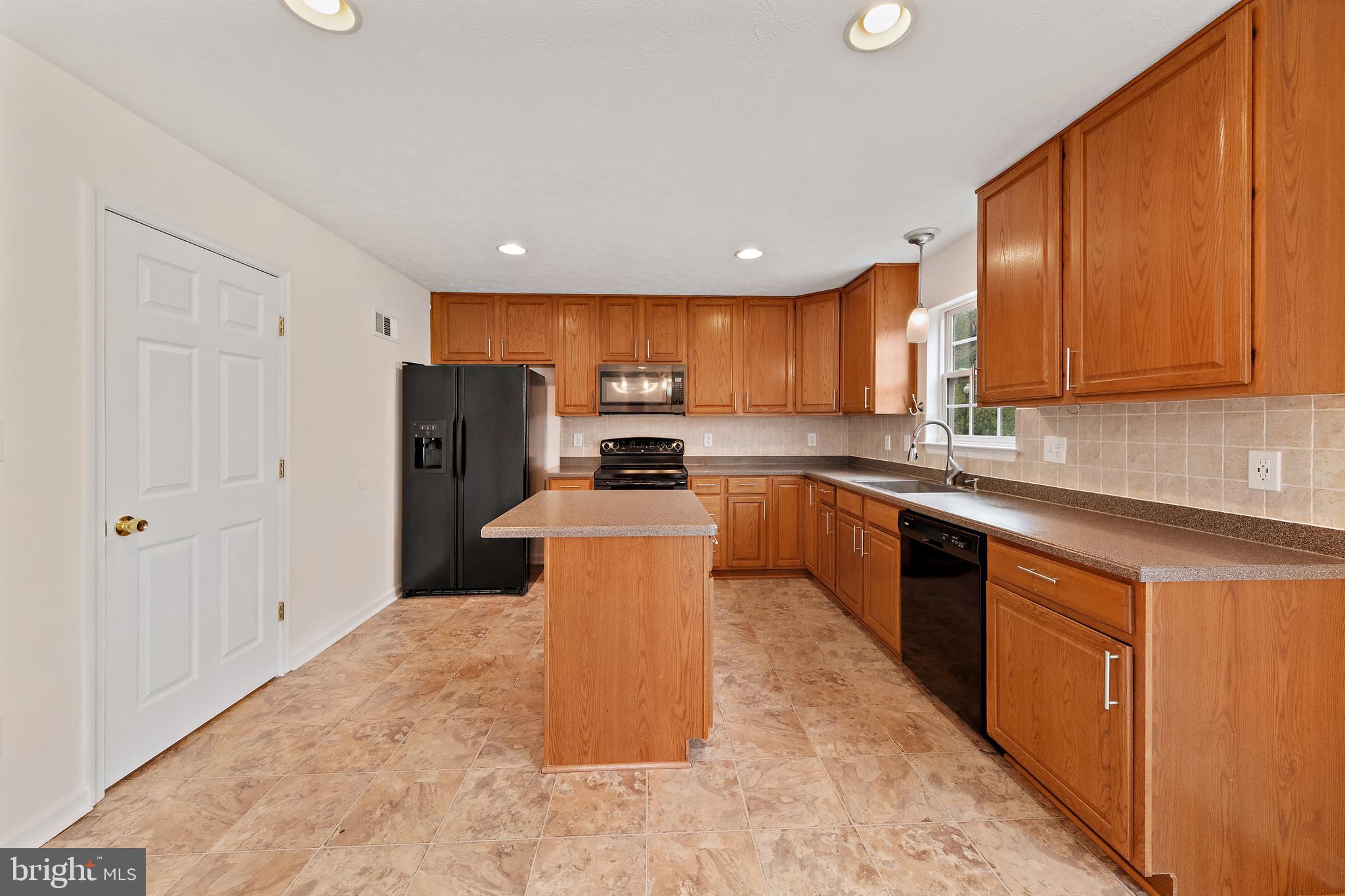 1612 Cattail Commons Way Denton, MD 21629 - Photo 27 of 67 a kitchen with stainless steel appliances granite countertop a refrigerator sink and cabinets