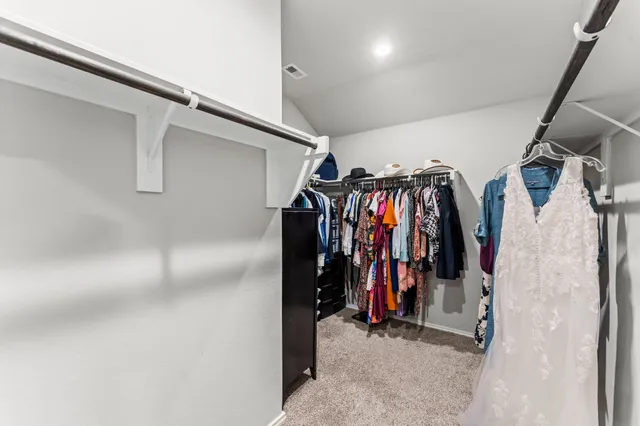 a view of walk in closet with clothes