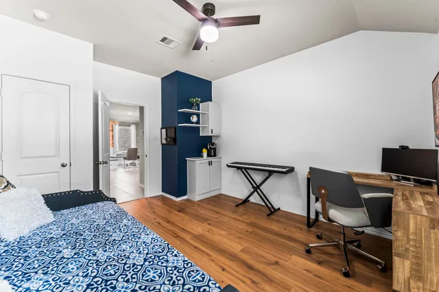a bedroom with a bed and wooden floor