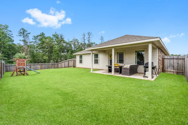 a view of a house with backyard and porch