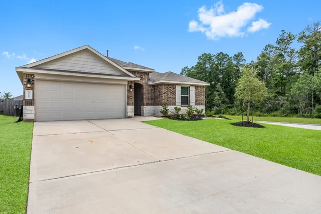 a front view of a house with a yard and trees