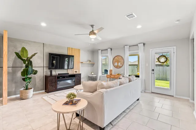 a living room with furniture a chandelier and a dining room