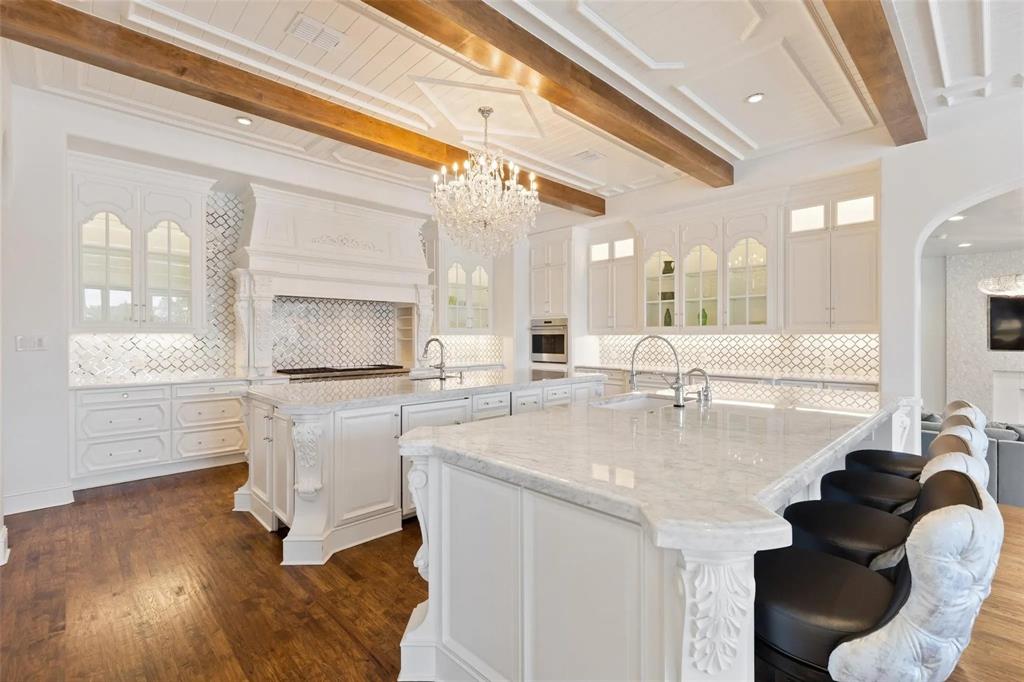 935 West Dove Road Southlake, TX 76092 - Photo 12 of 38 a kitchen with a sink dishwasher a stove and a dining table with wooden floor