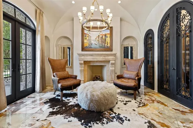 a living room with furniture a fireplace and a chandelier