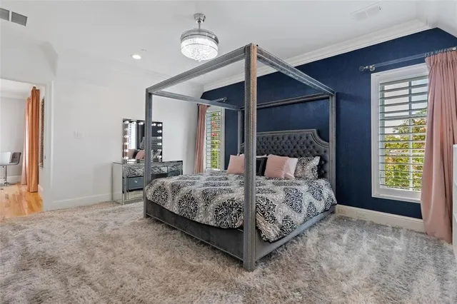 a bed sitting in a spacious bedroom next to a window