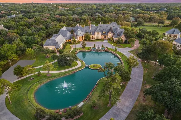 an aerial view of a residential houses with outdoor space and lake view
