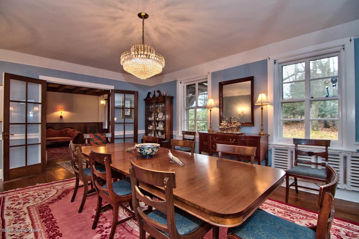 24 Summit Avenue Pocono Manor, PA 18349 - Photo 16 of 114 a dining room with wooden floor a chandelier a wooden table and chairs