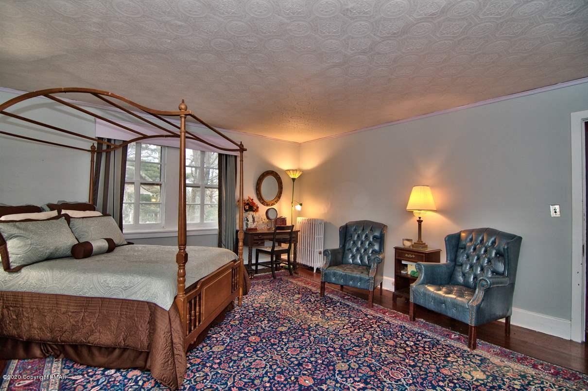 24 Summit Avenue Pocono Manor, PA 18349 - Photo 43 of 114 a bedroom with a bed a mirror on dresser and a large window