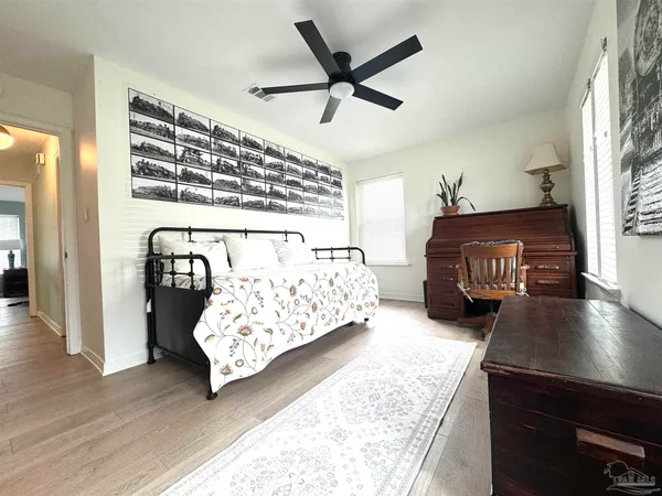 a living room with a bed furniture and a ceiling fan
