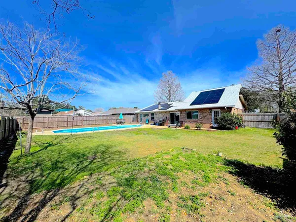a view of a house with pool and a yard