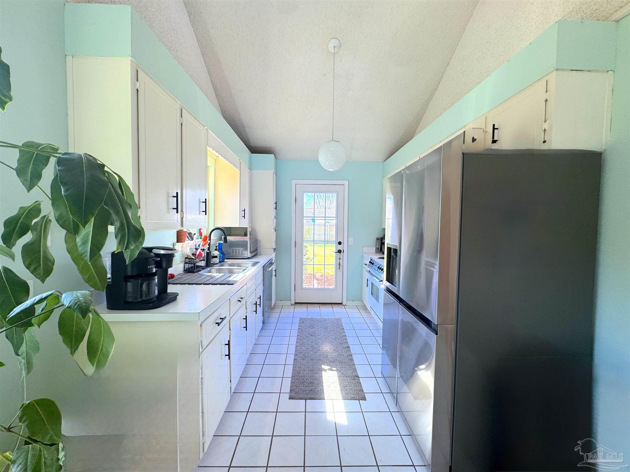 3585 Riddick Drive Pensacola, FL 32504 - Photo 9 of 22 a kitchen with sink a refrigerator and potted plant