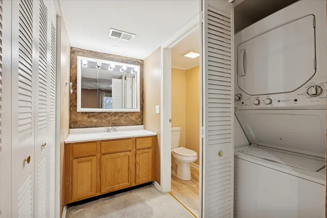 a bathroom with a granite countertop toilet sink and mirror