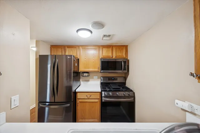 a kitchen with stainless steel appliances a refrigerator stove and microwave