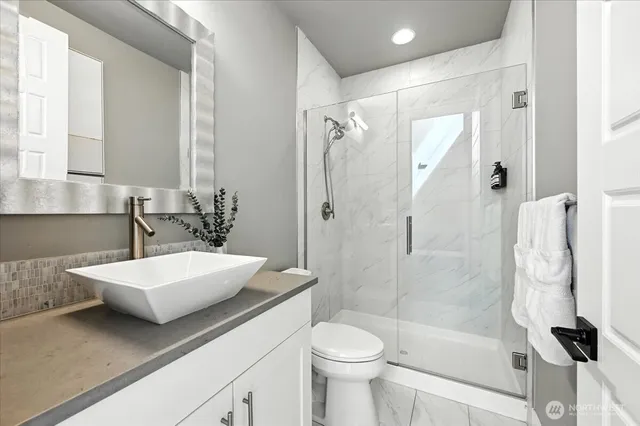 a bathroom with a sink a toilet and shower