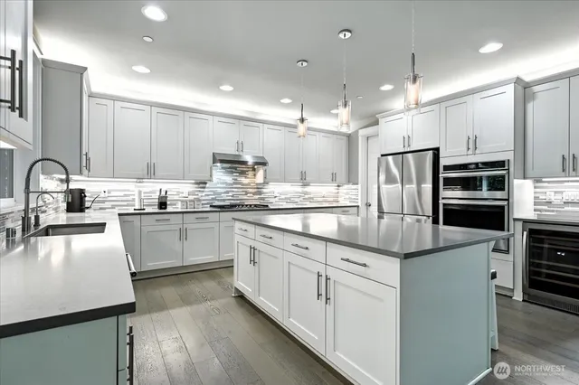 a kitchen with kitchen island granite countertop appliances cabinets and a sink