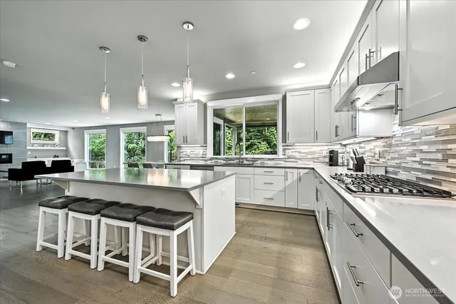 a kitchen with stainless steel appliances granite countertop a stove a sink a oven a dining table and chairs