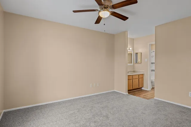 an empty room with chandelier fan