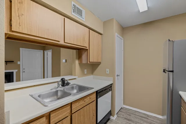 a kitchen with a refrigerator and a stove top oven