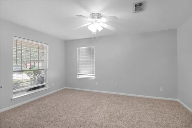a view of an empty room with a fireplace and a window