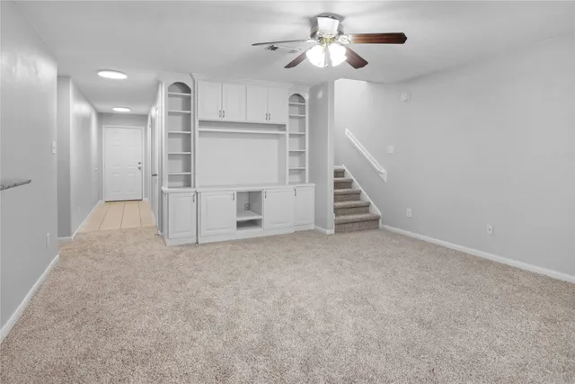 an empty room with a chandelier fan