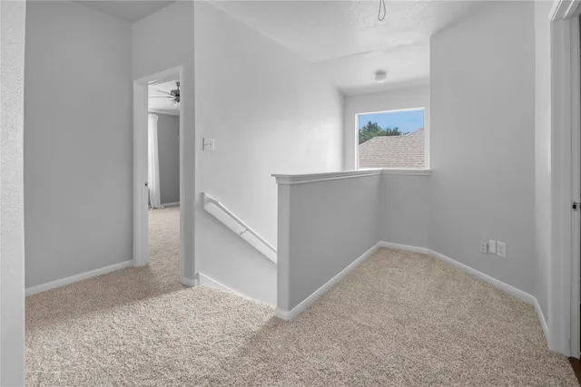 an empty room with a window and a fan