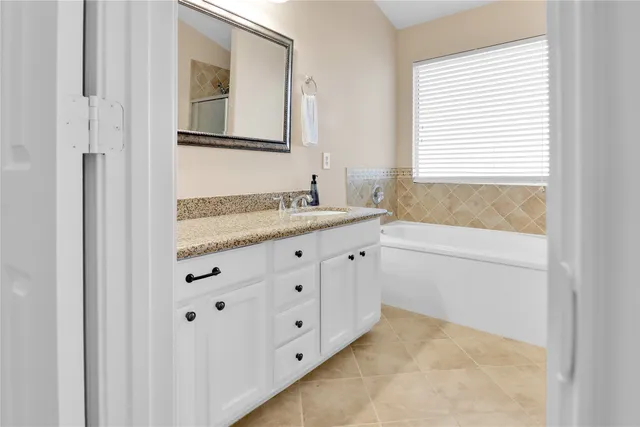 an empty room with a chandelier fan and windows