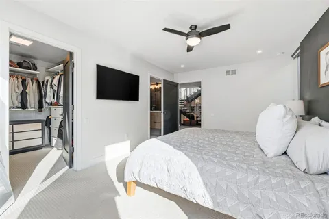 a spacious bedroom with a bed and a flat screen tv