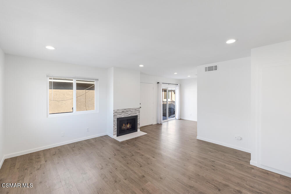 577 Spring Road, Unit 56 Moorpark, CA 93021 - Photo 5 of 19 a view of empty room with wooden floor and fireplace