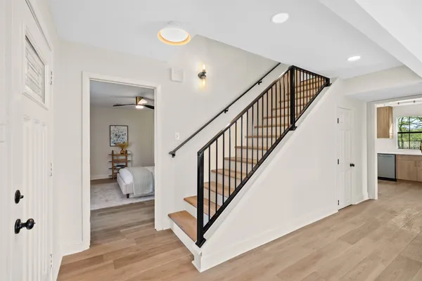 a view of a hallway with wooden floor and stairs