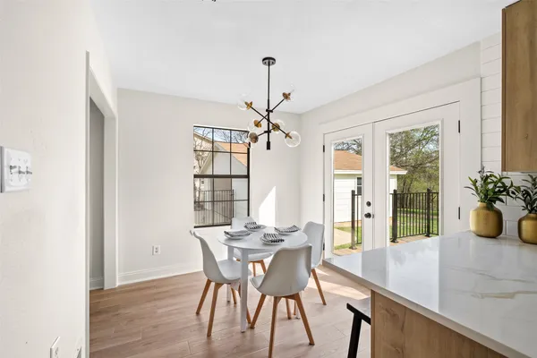 a dining room with furniture potted plants and wooden floor