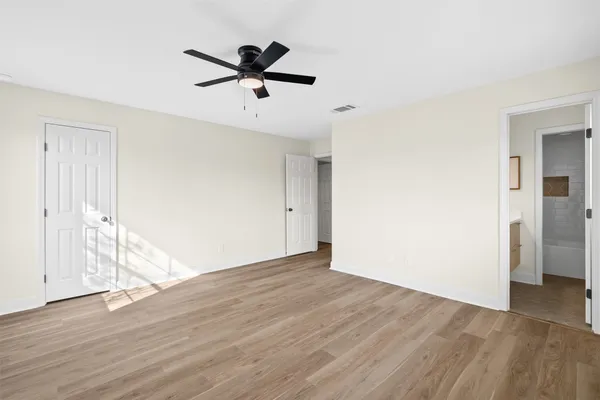 an empty room to closet area with wooden floor