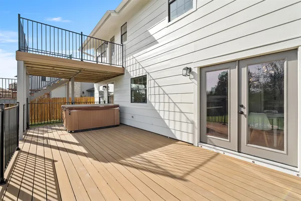 a view of a balcony with wooden floor and iron stairs