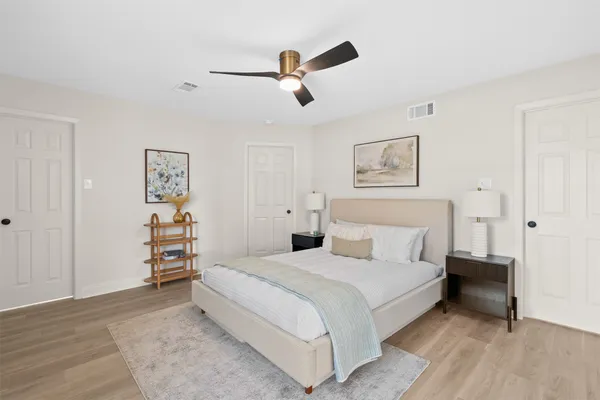 a bedroom with a bed and painting on the wall