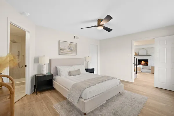 a bedroom with a large bed and a chandelier