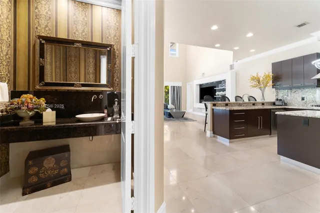 a kitchen with granite countertop a stove a sink and a refrigerator