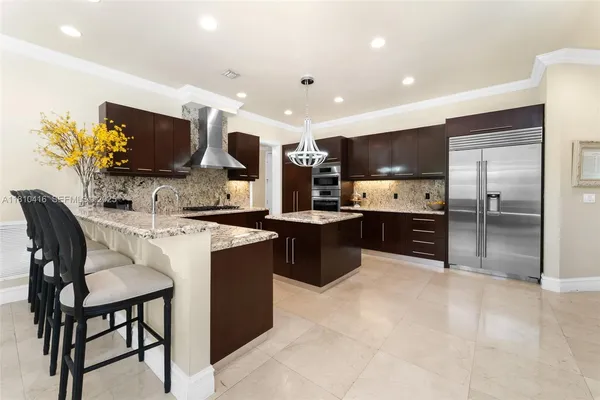 a kitchen with stainless steel appliances a sink counter space and a view of living room