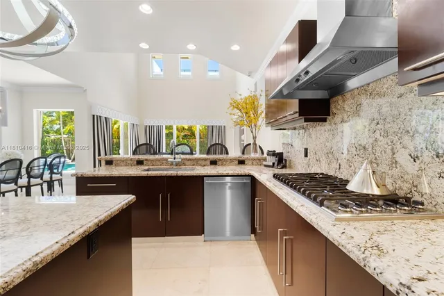 a kitchen with stainless steel appliances granite countertop a sink a stove and a wooden cabinets