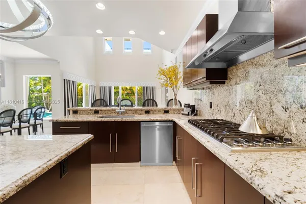 a kitchen with stainless steel appliances granite countertop a sink a stove and a wooden cabinets