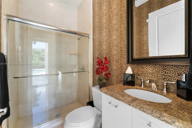 a bathroom with a granite countertop sink toilet and shower