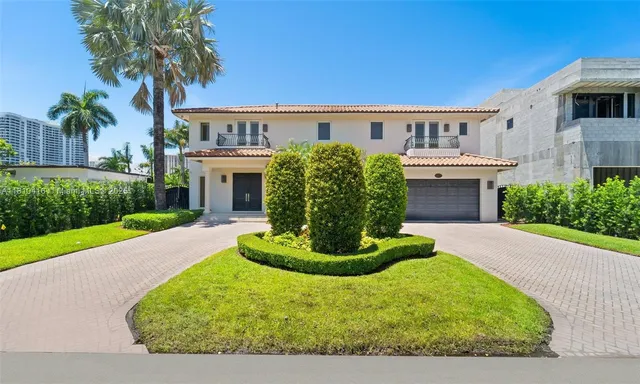 a view of a house with a yard and potted plants