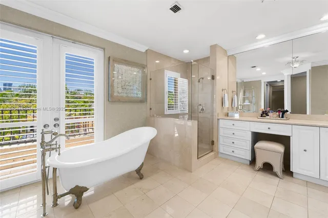 a spacious bathroom with a double vanity sink a mirror a bathtub and next to a window