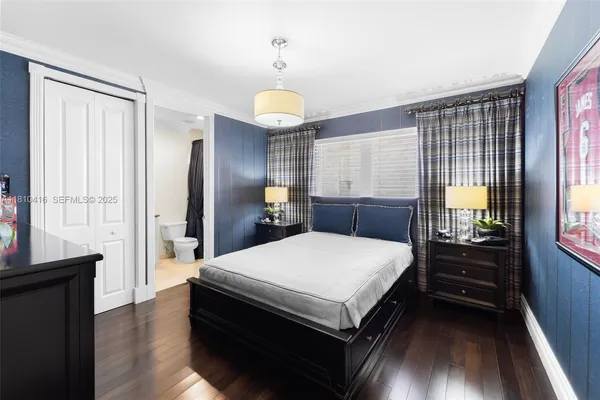 a large bedroom with a bed and wooden floor