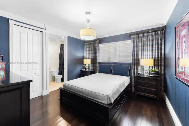 a large bedroom with a bed and wooden floor