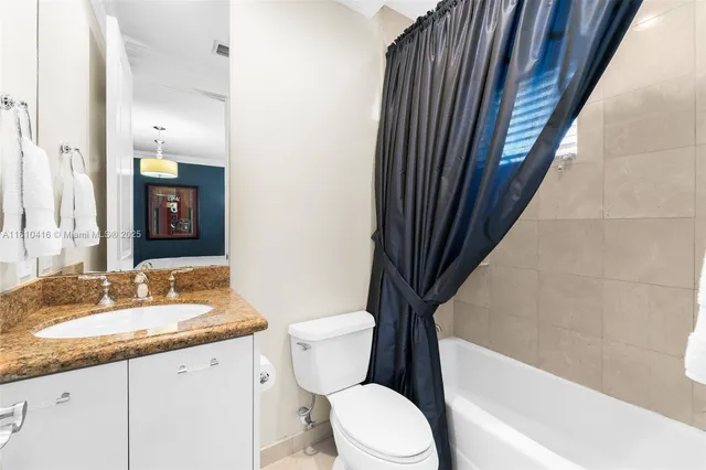 a bathroom with a granite countertop sink toilet and shower