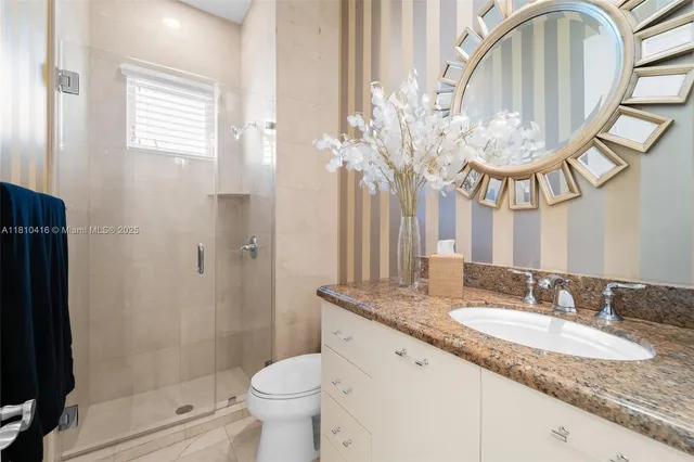 a bathroom with a granite countertop sink a toilet and a mirror